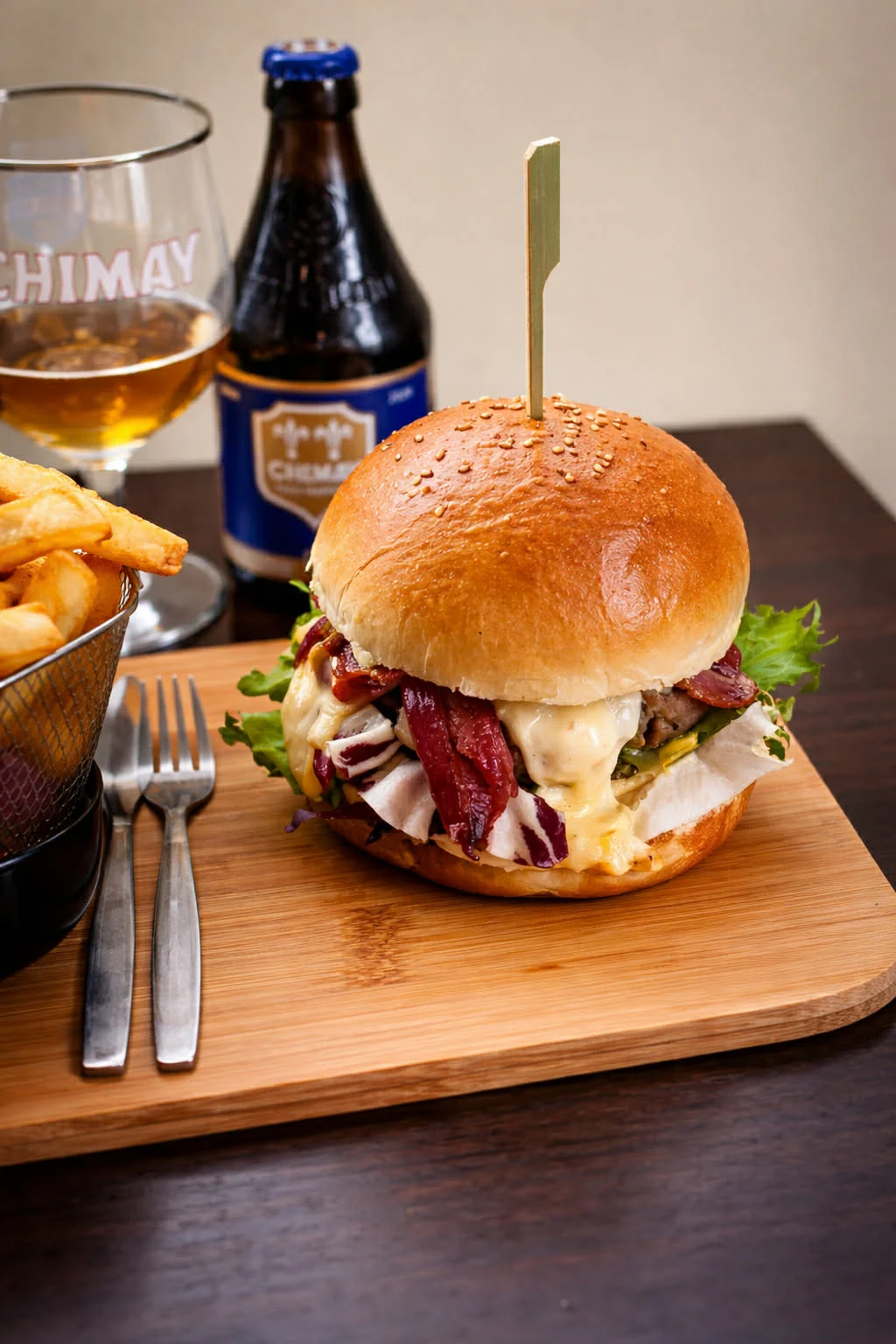 Burger généreux au fromage Chimay, bacon et salade, servi avec frites maison, proposé dans le cadre du service horeca de Soegito en Belgique